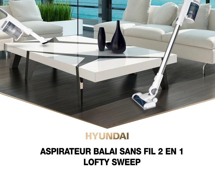 aspirateur balai Lofty Sweep dans un salon à coté d'un canapé et d'une table basse